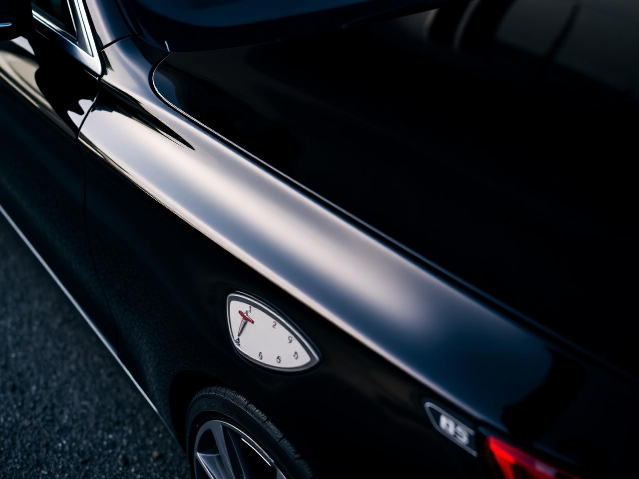 Glossy black sedan paint reflection